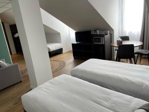 um quarto de hotel com duas camas e uma mesa e um quarto em Kyriad Crepy En Valois em Crépy-en-Valois