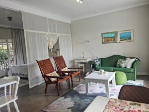 a living room with a green couch and chairs at Maria's in Melville in Johannesburg