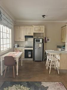 a kitchen with a refrigerator and a table with chairs at Maria's in Melville in Johannesburg