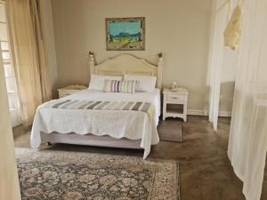 a bedroom with a large white bed and a rug at Maria's in Melville in Johannesburg