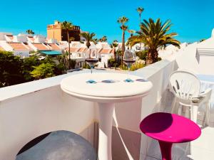 a table with two glasses of wine on a balcony at Beach Bungalow Holiday Home in Adeje