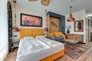 a bedroom with a large bed and a couch at Granaria Comfort Apartments in Gdańsk
