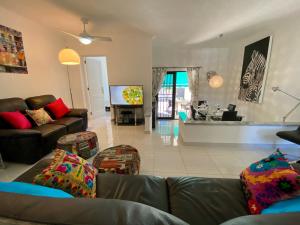 a living room with a couch and a tv at Beach Bungalow Holiday Home in Adeje