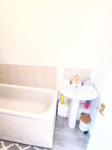 a bathroom with a tub and a sink and a toilet at Northern Breeze Apartment in Cambois