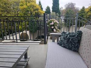 una panchina su un balcone con cancello e fiori di Maria's in Melville a Johannesburg