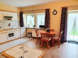 a kitchen with a wooden table and a table and chairs at Hof Böhmetal in Schneverdingen