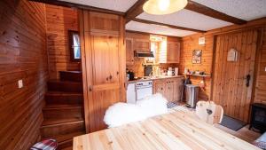 AyerにあるChalet Bella Vouarda. Cosy traditional alpine stayの木製の壁のキッチン、キャビン内のテーブル