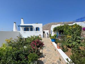 a row of white houses with flowers and plants at Cycladic houses in rural surrounding 3 in Tholária