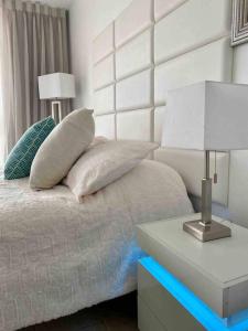 a bed with two pillows and a table with a lamp at Alojamiento con balcon hacia la playa 115 in Miami Beach