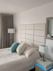 ein Schlafzimmer mit einem Bett mit Kissen und einem Spiegel in der Unterkunft Alojamiento con balcon hacia la playa 115 in Miami Beach