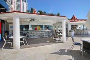 a patio with tables and chairs and a bar at Alojamiento con balcon hacia la playa 115 in Miami Beach