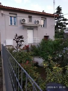 a white house with a fence in front of it at Anadora 2: Hospitable stone house with yard in Alexandroupoli