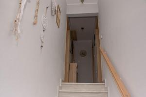 un pasillo con escaleras y artículos colgando en la pared en Anadora 2: Hospitable stone house with yard, en Alexandroupoli