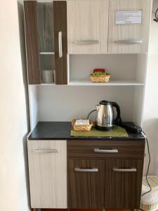 a kitchen cabinet with a tea kettle on a counter at Habitación en suite, Excelente Ubicación in Asuncion
