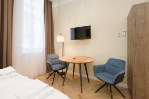 pokój ze stołem, dwoma krzesłami i łóżkiem w obiekcie Vienna Stay Apartments Pezzl 1170 w Wiedniu