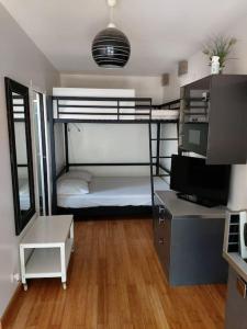 Pokój z łóżkiem piętrowym i biurkiem z komputerem w obiekcie STUDIO LUXE 600M PLAGE AVEC SPA POUR 4 PERS w Cap d'Agde