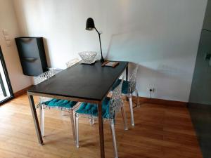 uma mesa de jantar preta com cadeiras e um candeeiro em STUDIO LUXE 600M PLAGE AVEC SPA POUR 4 PERS em Cap d'Agde
