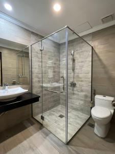 uma casa de banho com um chuveiro, um WC e um lavatório. em Wing Tat Grand Hotel em Semporna