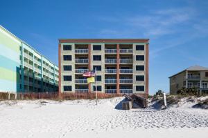 a building on the beach with a flag in front of it at Harbor Place 313 Beach Front Gulf View in Gulf Shores