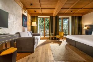a bedroom with a bed and a couch and a tv at Ana Hotels Bradul Poiana Brasov in Poiana Brasov