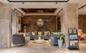 a lobby with couches and a table and a mirror at Lazdana Hotel Bangalore in Bangalore