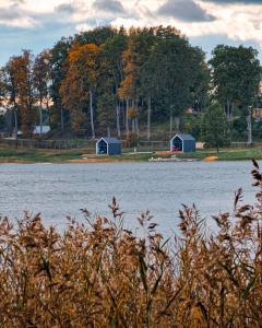 a view of a body of water with two houses at PullanHouse Līksma - small and cosy lakeside holiday house in Alūksne