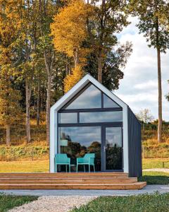 a small shed with a table and chairs in it at PullanHouse Līksma - small and cosy lakeside holiday house in Alūksne +6 photos