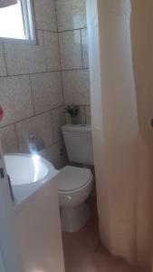 uma casa de banho com um WC branco e um lavatório. em Alojam Las Heras 10 Off Termas em Villa Elisa