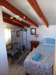 um quarto com uma cama e uma cadeira em Tara Casa Rural em Cartagena