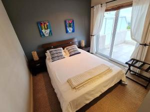 um quarto com uma cama com lençóis brancos e uma janela em Palm Zicht MAIN 3 bedroom apartment em Cidade do Cabo