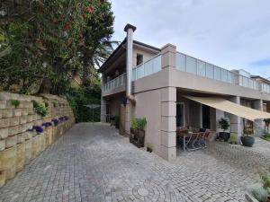 a house with a patio and a building at Palm Zicht MAIN 3 bedroom apartment in Cape Town