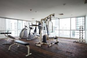 un gimnasio con equipo cardiovascular en una gran sala con ventanas en Sha2bedrooms Ensuite3baths Bangkok Downtown Mrt en Bangkok