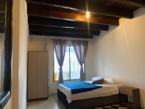 a small bedroom with a bed and a window at Casa Hotel Marbella Beach in Cartagena de Indias