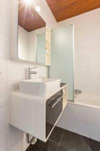 a white bathroom with a sink and a tub at Riverview Studio in Historical Heart of Antwerp in Antwerp