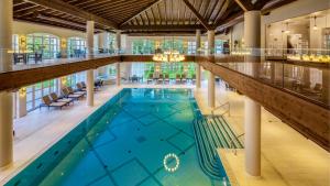 uma grande piscina num edifício com um tecto grande em Ana Hotels Bradul Poiana Brasov em Poiana Brasov