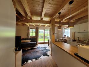 恩吉尔波登Tauerndorf Enzingerboden Ski in&out - Steinbock Lodges的厨房和客厅设有木制天花板。
