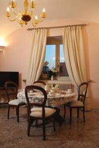 a dining room with a table and chairs and a chandelier at Le Scalelle B&B in Scorpeto