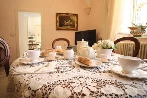 a dining room table with a table cloth with tea sets on it at Le Scalelle B&B in Scorpeto