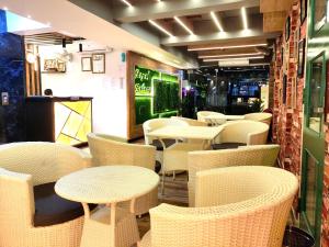Royal Galaxy في كولْكاتا: مطعم فيه طاولات وكراسي في الغرفة