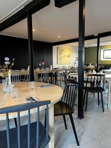 une salle à manger avec des tables et des chaises en bois dans l'établissement Svabesholms Kungsgårds B&B och Pensionat Stenshuvud, à Kivik