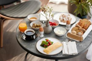a breakfast table with breakfast foods and orange juice at Teight Hotel in Thessaloniki