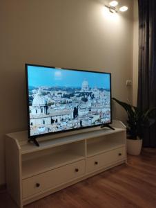 einen Flachbild-TV auf einem Stand in einem Wohnzimmer in der Unterkunft Havel Apartment in Oppeln