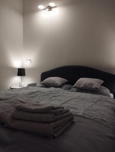 a bed with two pillows and towels on it at Havel Apartment in Opole