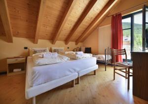 1 Schlafzimmer mit 3 Betten in einem Zimmer mit Holzdecken in der Unterkunft Casa Cola in Valdidentro