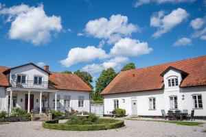 a group of white houses with a courtyard at Svabesholms Kungsgårds B&B och Pensionat Stenshuvud in Kivik