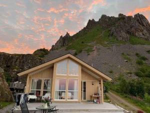 una piccola casa con una montagna sullo sfondo di Lofotparadis - nydelig hytte på unikt sted a Valberg
