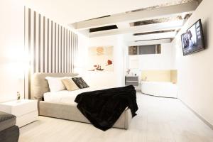 a white bedroom with a bed and a tv at Memorable Jacuzzi Suite Navona - Top Collection in Rome