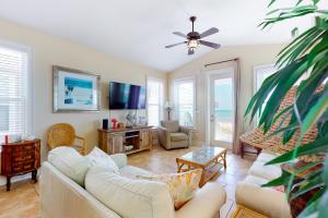 uma sala de estar com dois sofás e uma televisão em Beauty And The Beach em St. George Island