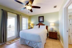 a bedroom with a bed and a ceiling fan at Beauty And The Beach in St. George Island
