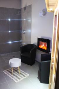 łazienka z kominkiem, krzesłem i prysznicem w obiekcie Maison avec piscine, jacuzzi et sauna privatifs - Mas de Nebbas w Aix-en-Provence